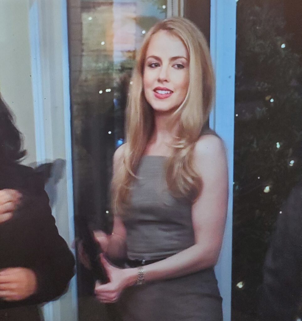 Meredith from Pretty Little Liars entering the gallery wearing a gray strapless form-fitting dress with a thin black belt