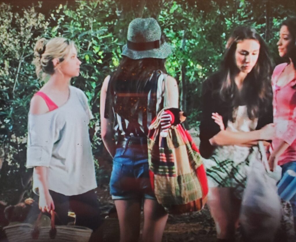 Shot of all the Liars in the woods – Aria is wearing a black and white striped sleeveless top with denim shorts and a black belt, as well as a green hat with a black band around it.