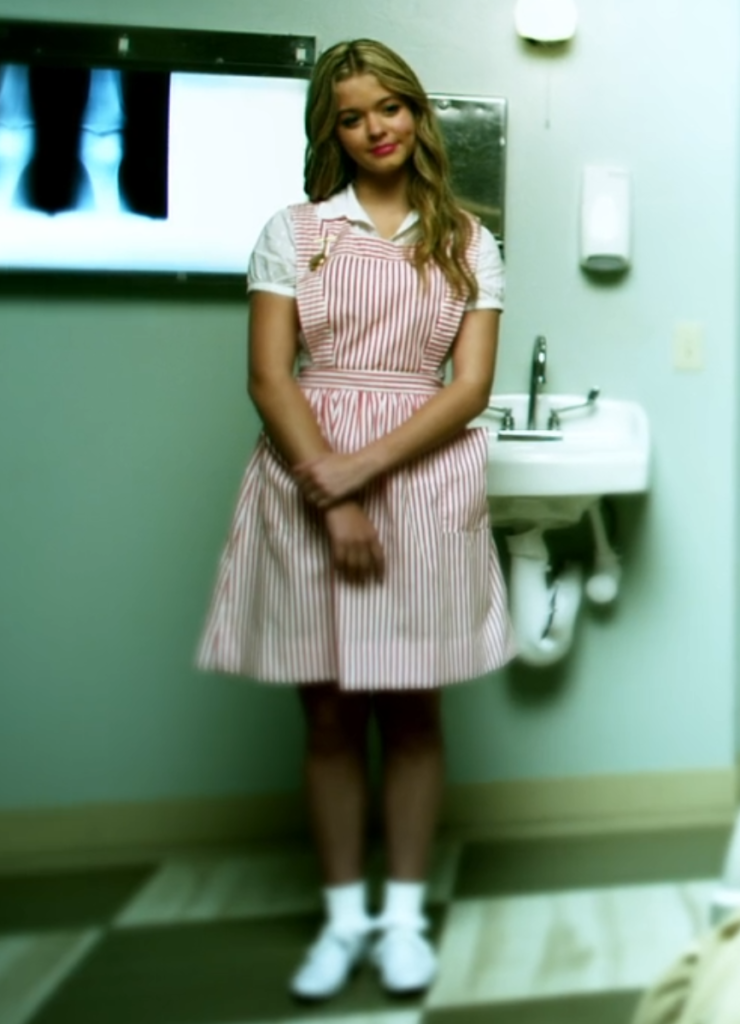Wide shot of Alison wearing a red-and-white candy striper outfit