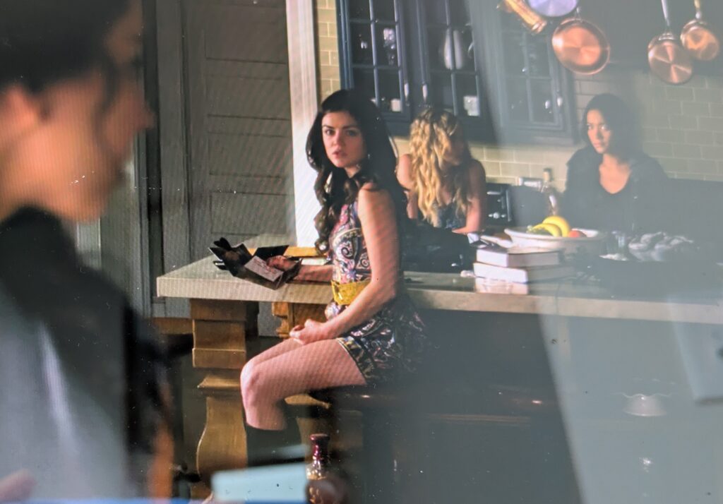 Wider shot of Aria, where you can see she has a beaded yellow waist belt over the dress and black boots on as well