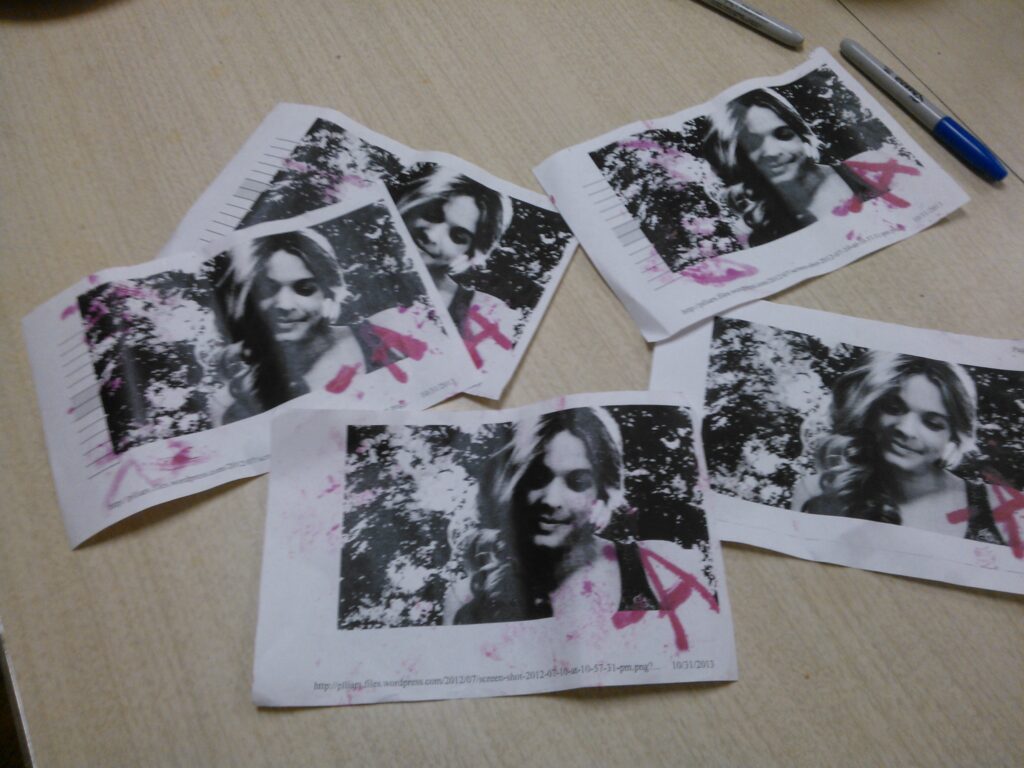 Five black and white printouts of photos of Alison with "A" written on them in red marker